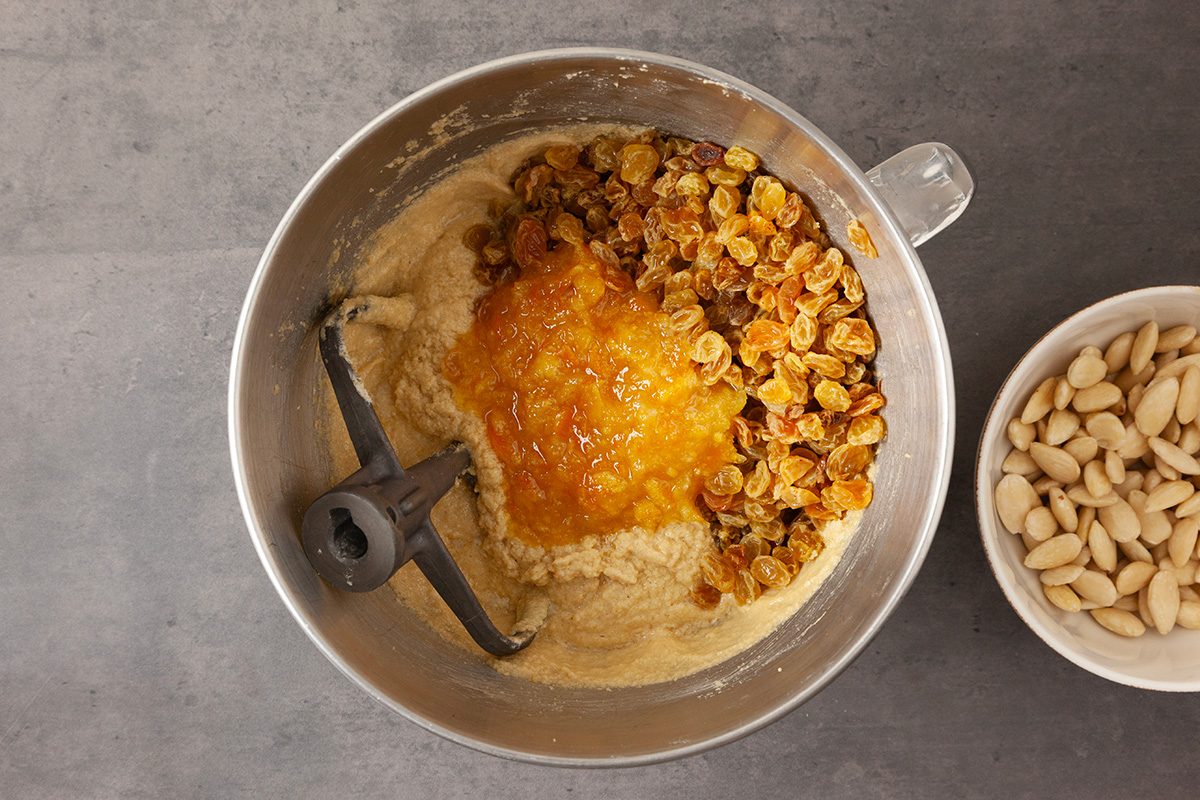 Beat in eggs, one at a time, until combined. Stir in orange marmalade, orange zest and soaked raisins until combined.