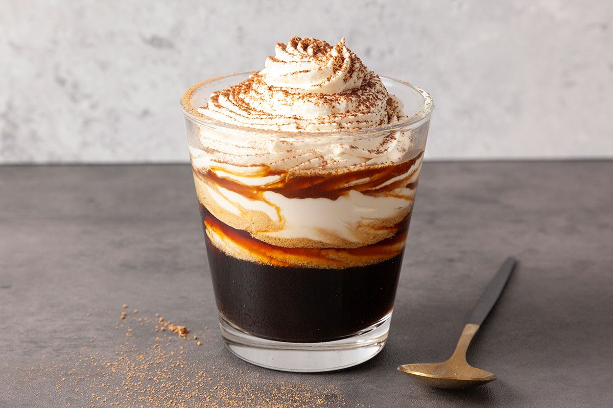 Einspanner Coffee in a mug with whipped cream on top.