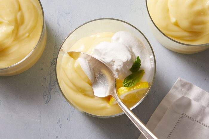 Overhead shot of Lemon Pudding topped with whipped cream, lemon slice and mint leaves