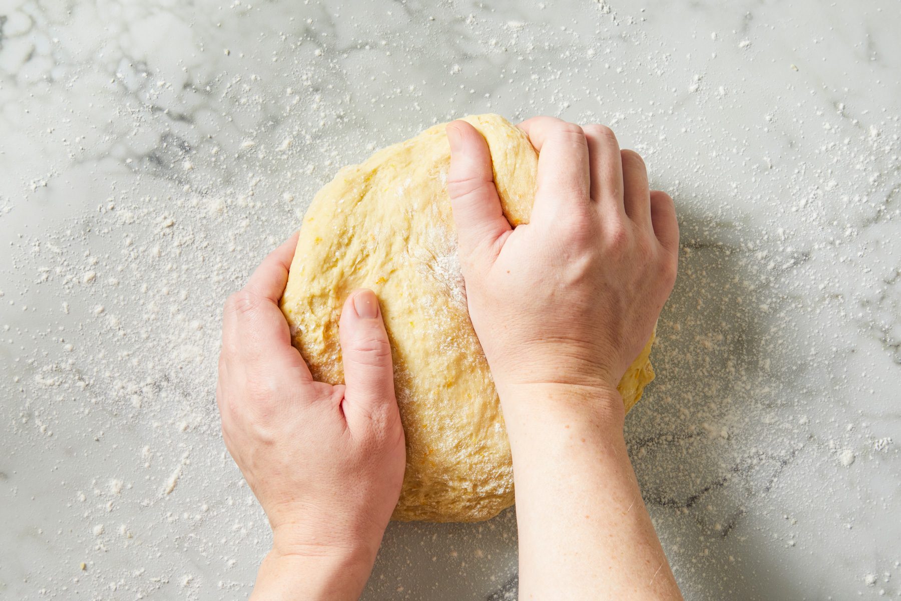 Overhead shot of turn out dough onto a floured surface; knead until smooth and elastic 6-8 minutes; marble surface;