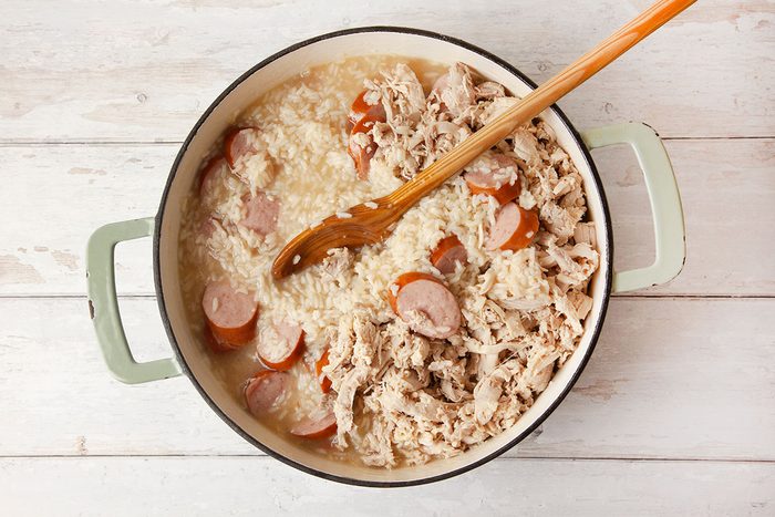 Chicken is being shredded in a stock pot