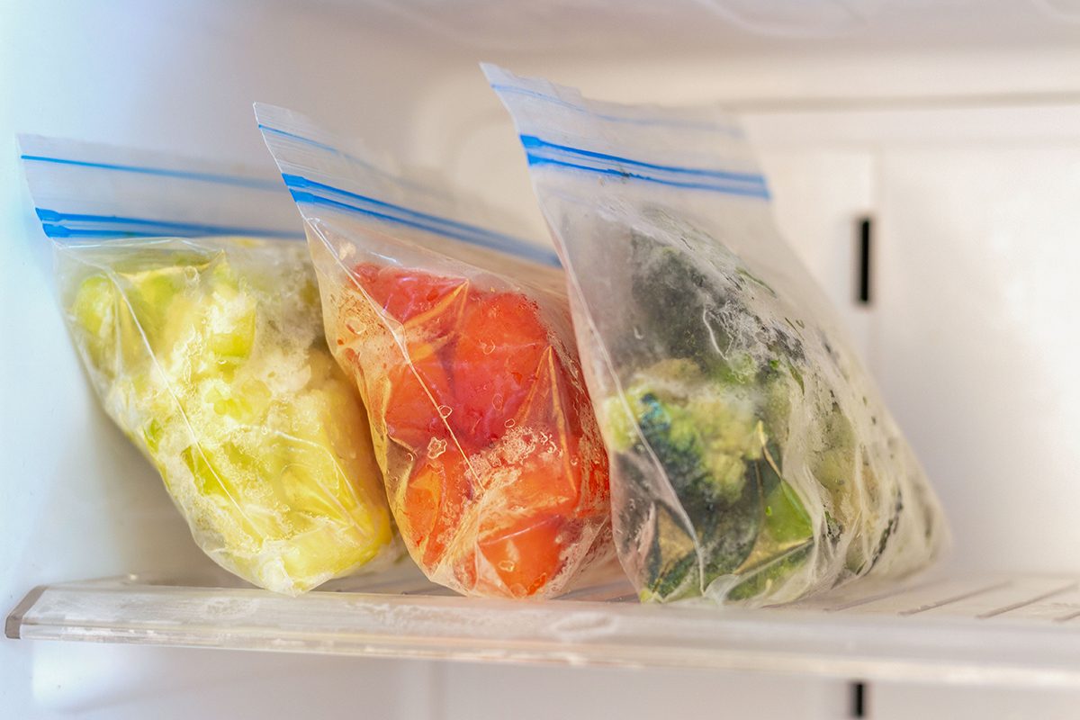 Frozen vegetables in plastic bags in freezer