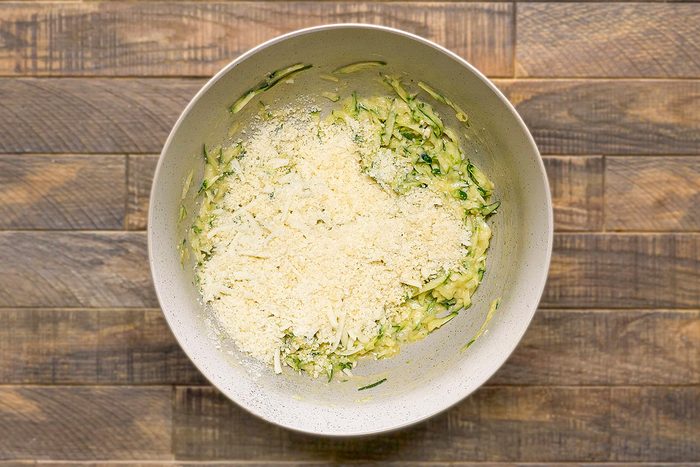 In a large bowl combine shredded zucchini; 2 eggs; flour and salt