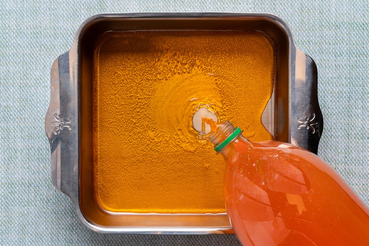 pour some orange soda into a freezer safe container