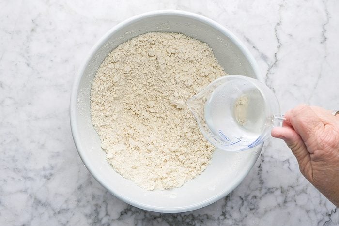 adding water to pastry mix in a bowl