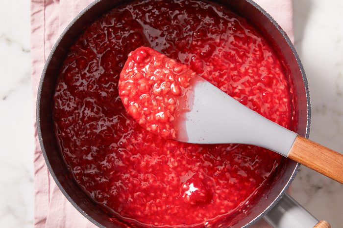 cooking and stirring raspberries, sugar and lemon water