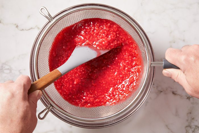 straining solids from raspberry swirl