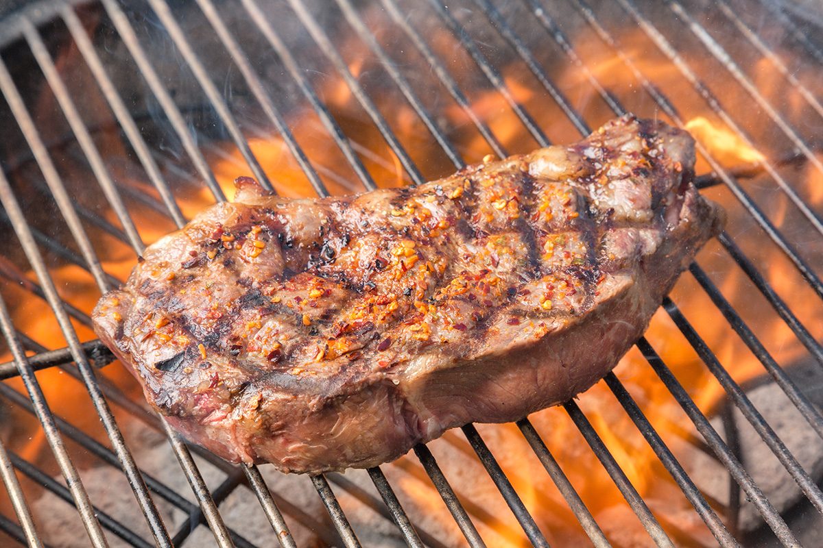 Juicy New York steak on the grill kissed by fire