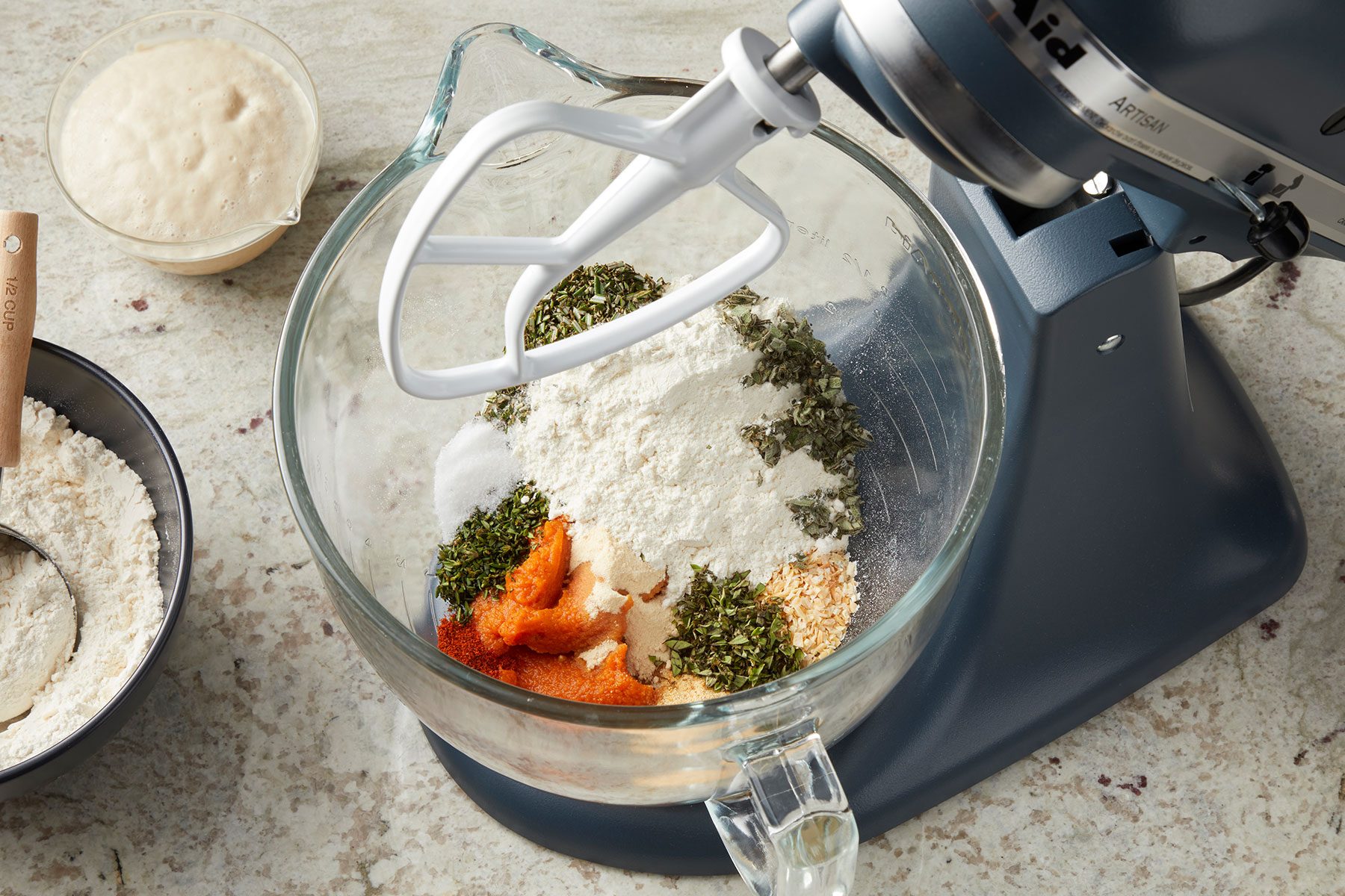Canned pumpkin, garlic powder, onion powder, dried minced onion, fresh herbs, salt, cayenne, yeast mixture with flour in a large bowl.