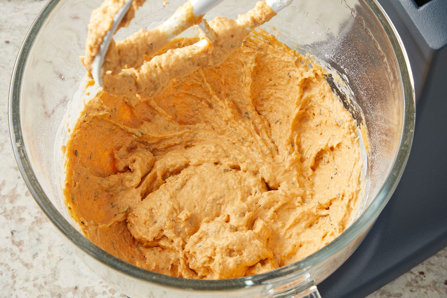 Pumpkin Shaped Rolls' beaten dough mixture in a glass bowl.