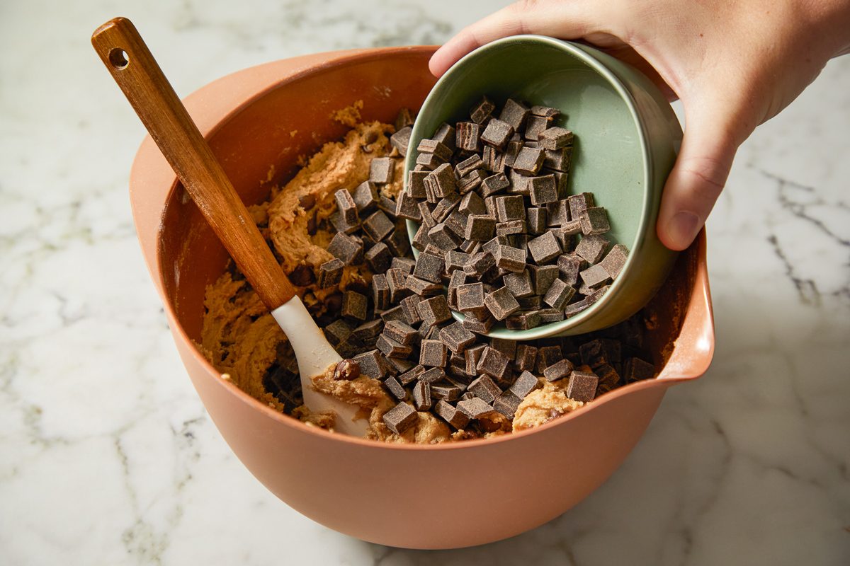 adding chocolate chips to cookie mixture