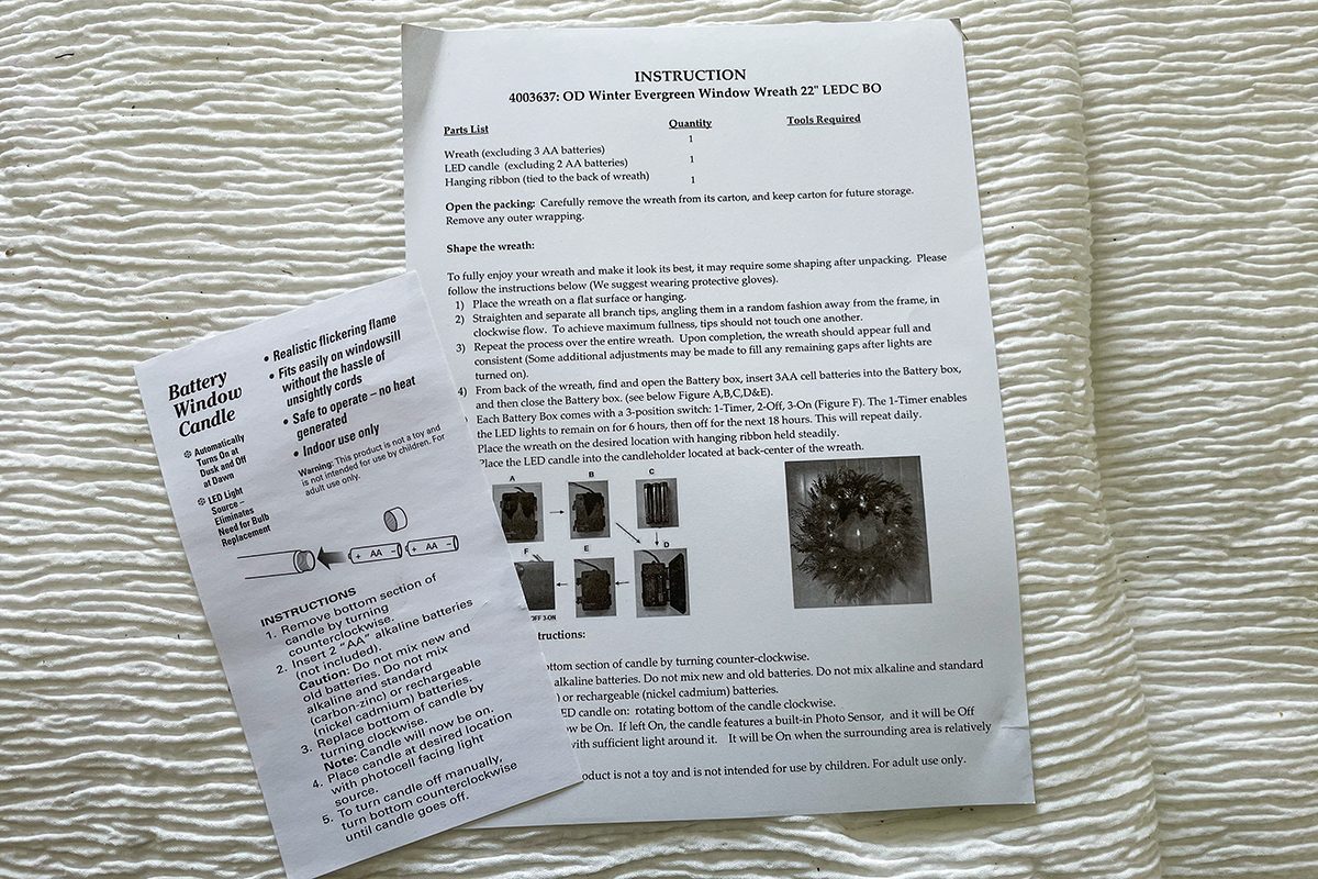 Two instruction sheets lay on a textured white surface. The larger sheet includes assembly steps and small images, while the smaller sheet, titled "Battery Caution," contains safety information and a simple illustration.