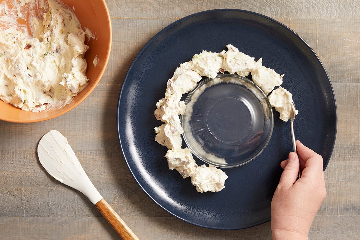 Invert a small bowl in the center of a serving platter. Drop cream cheese mixture by rounded tablespoonfuls around edge of bowl.