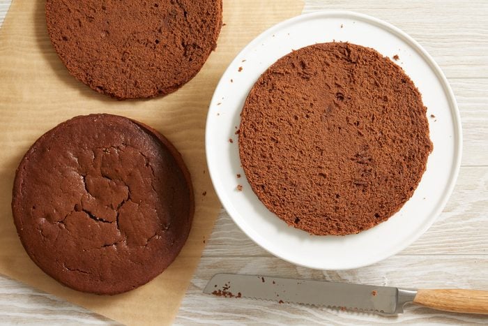 baked cake cut horizontally in half placed on a serving plate