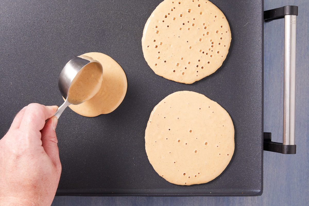 pancake batter poured onto a greased, hot griddle