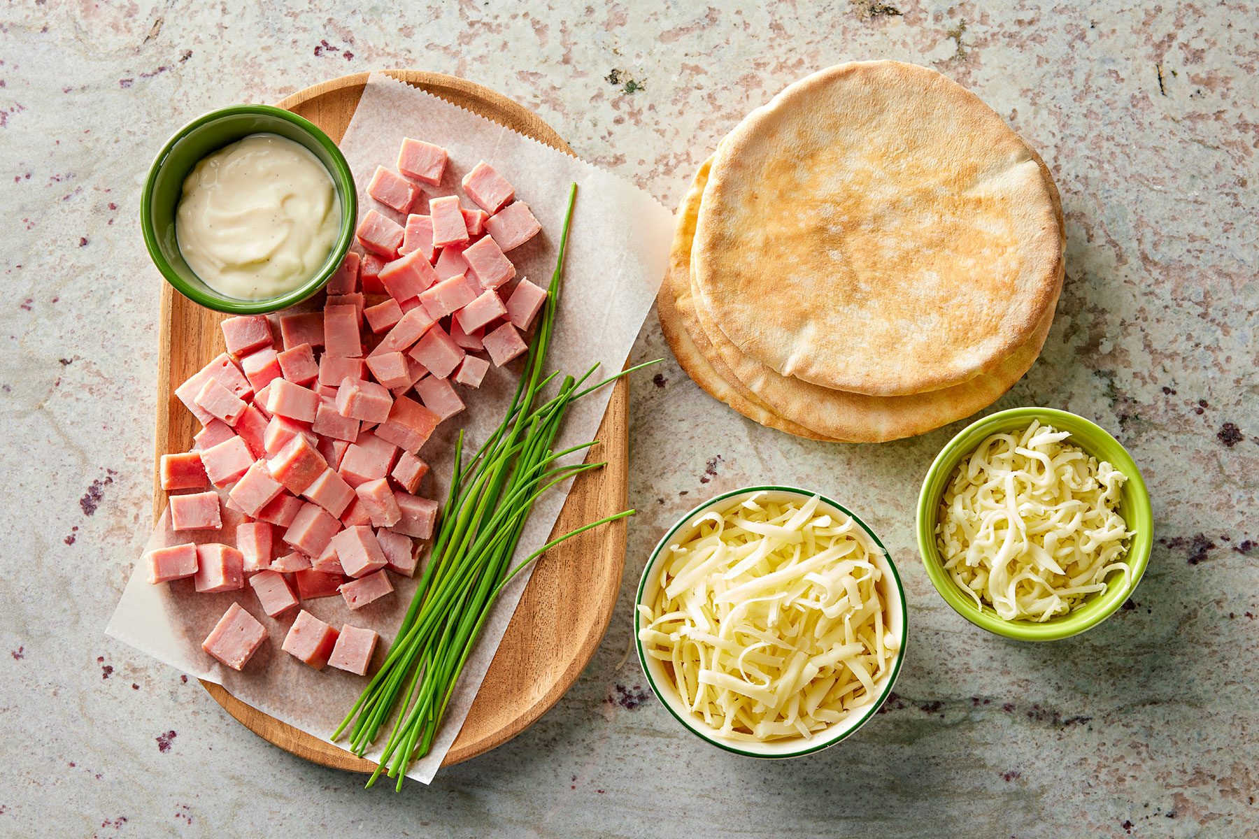 Ingredients for Pita Bread Pizza on plates and in bowls.