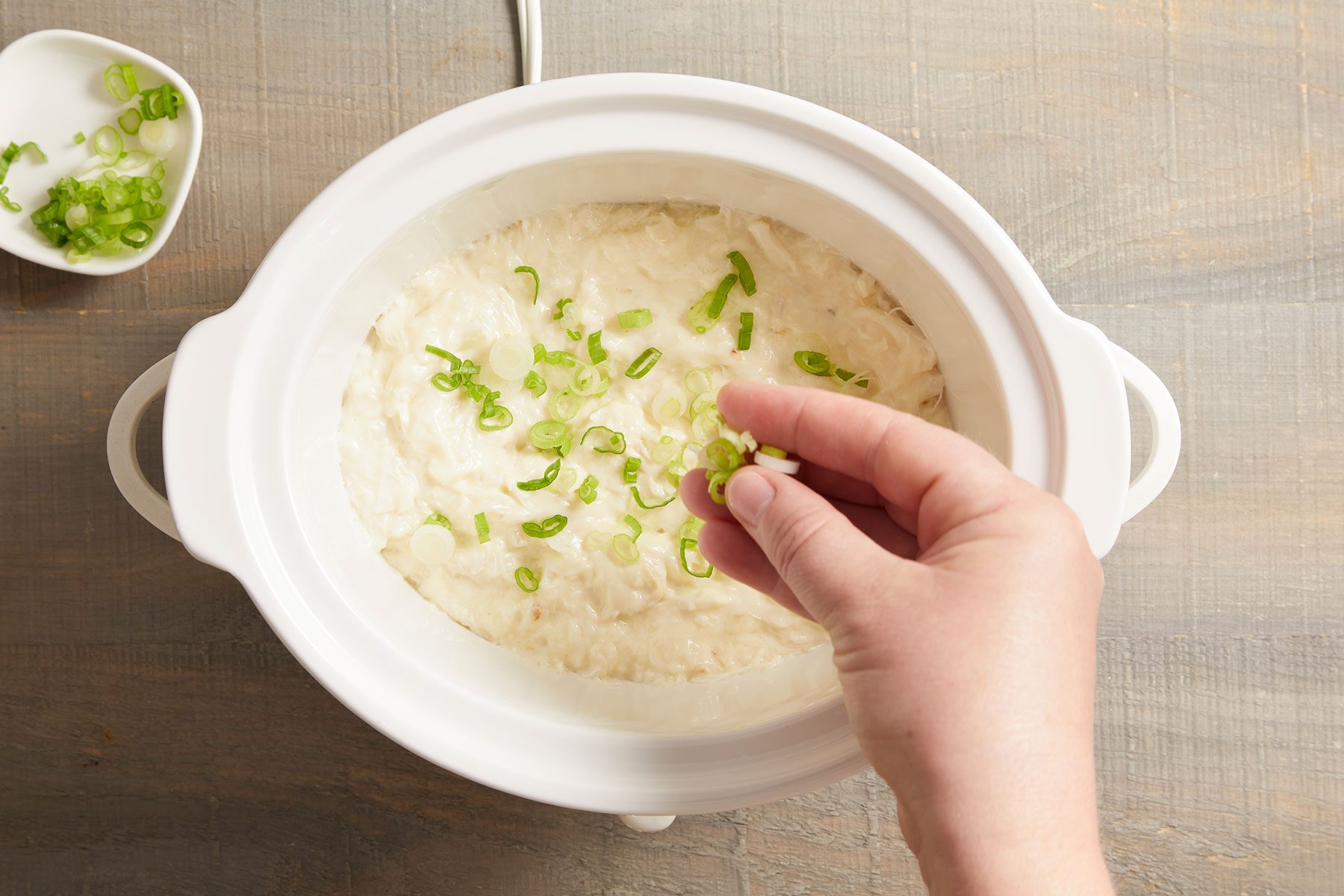 Sprinkling the dip with sliced green onions for a pop of color and fresh flavor.