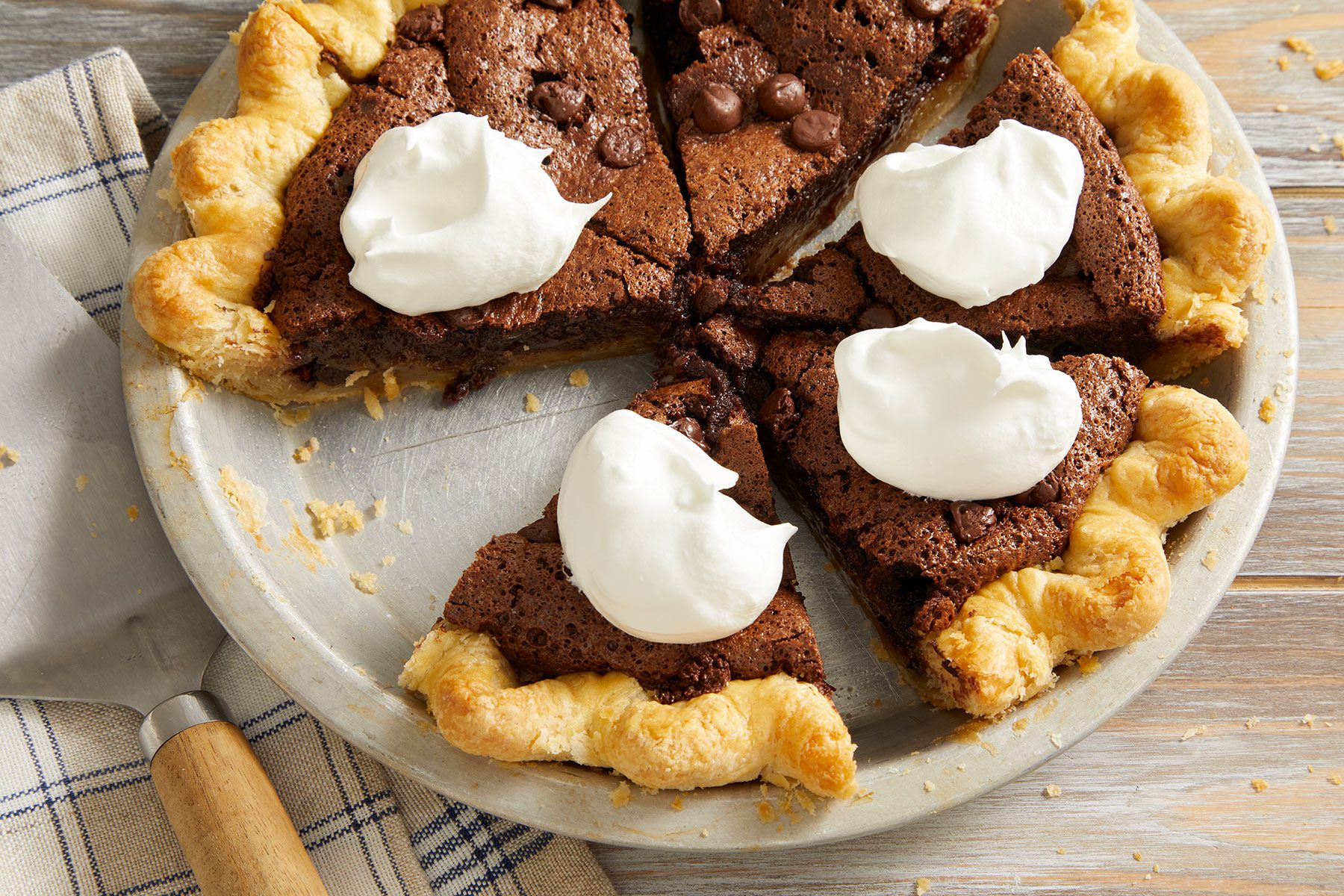Brownie Pie cut into small pieces with whipped cream on top of it.
