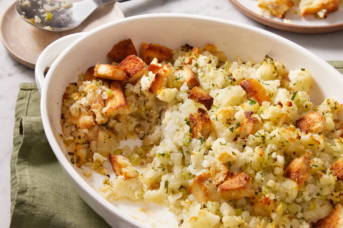 baked Potato Stuffing in an oval white casserole dish, golden and crisp on top.