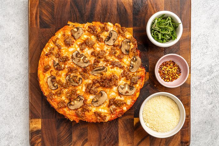 baked dutch oven pizza on a wooden board; seasonings