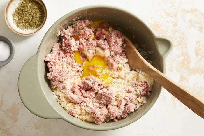 eggs, water, onion, bread crumbs, Parmesan cheese, garlic, and seasonings added to crumbled beef in a large bowl